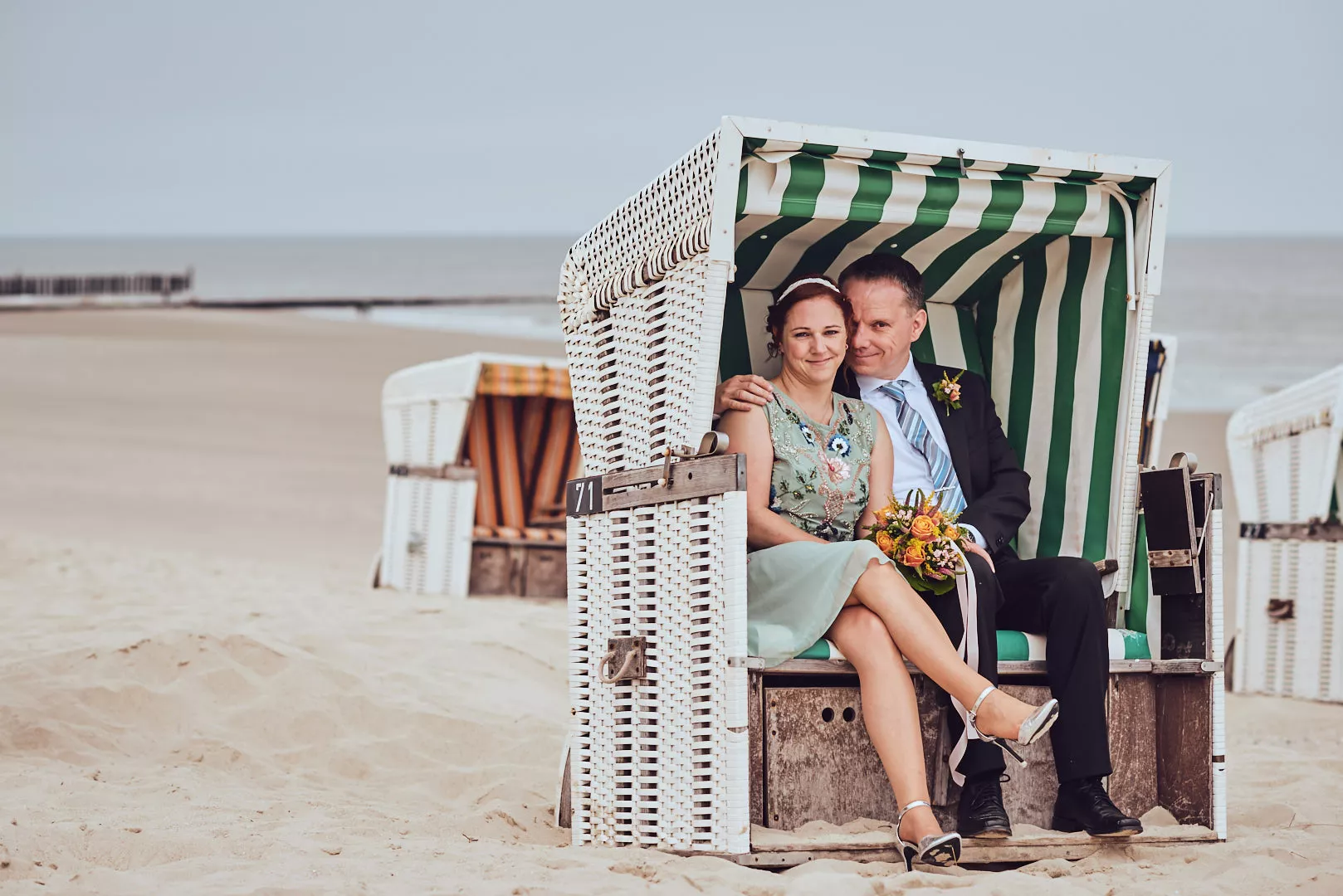Brautpaar sitzt im Strandkorb